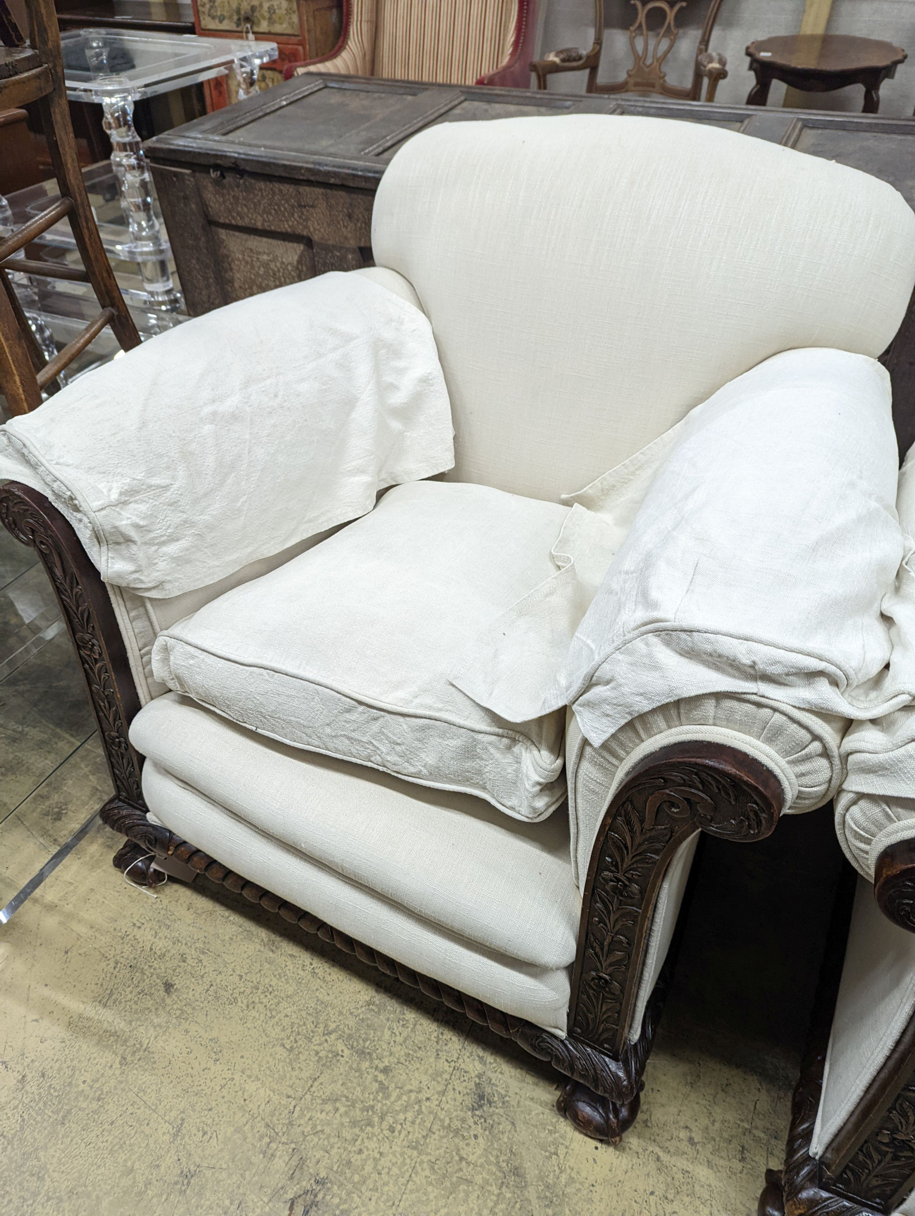 An early 20th century carved mahogany upholstered three piece lounge suite on claw and ball feet, the settee length 194cm, depth 80cm, height 80cm